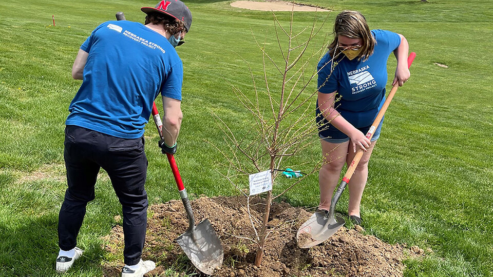Nebraska Strong Recovery Project outreach workers plant a tree in Nebraska City during an Arbor Day festival. 