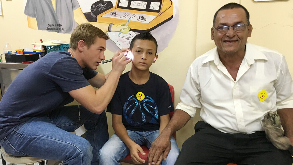 A student checks the ears of an adolescent in Nicaragua in 2016.
