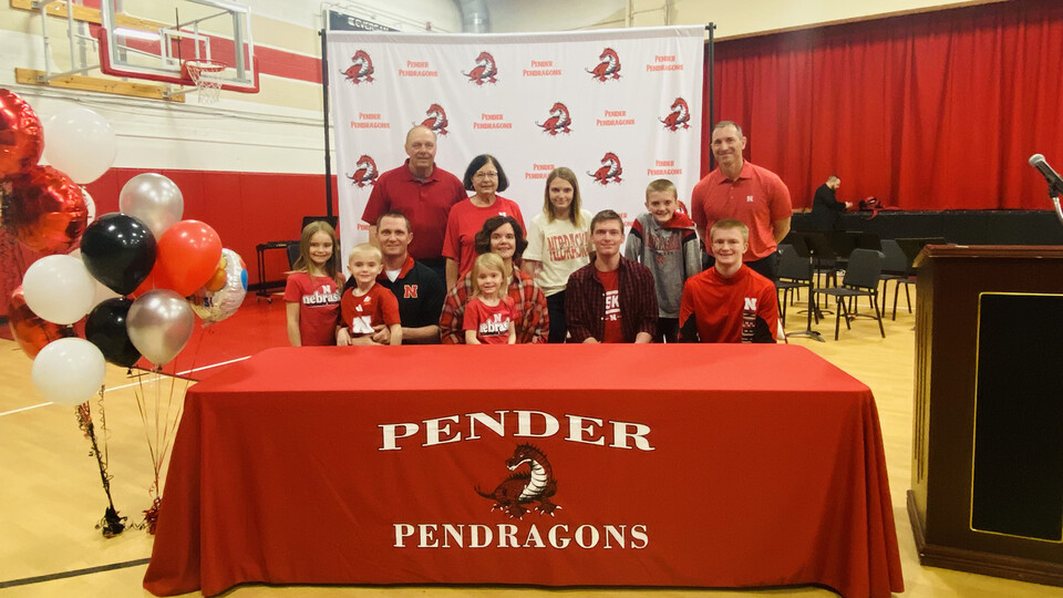 Caleb Henry (seated, second from right) signed as the University of Nebraska–Lincoln's first Presidential Scholar on March 5. He celebrated the day with his family, friends and members of the university community, including Chris Kabourek (standing, far right), interim president of the NU system.