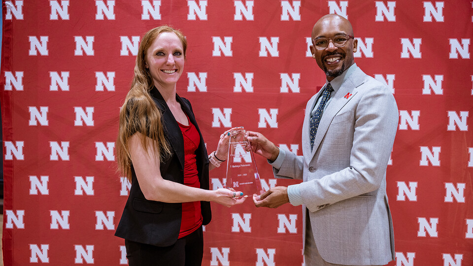 Markeya Peteranetz accepts the Diversity Leadership Staff award from Marco Barker, vice chancellor of diversity and inclusion.