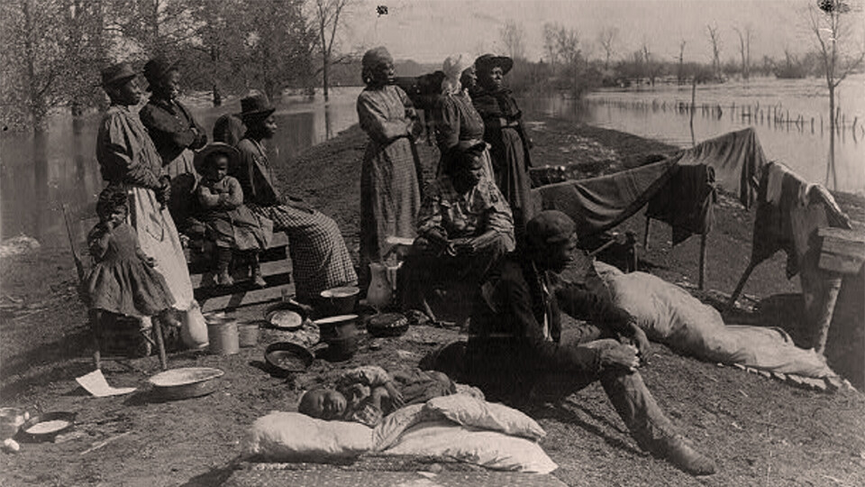 Black refugees rest on a levee along the Mississippi River in this image from April 17,1897.