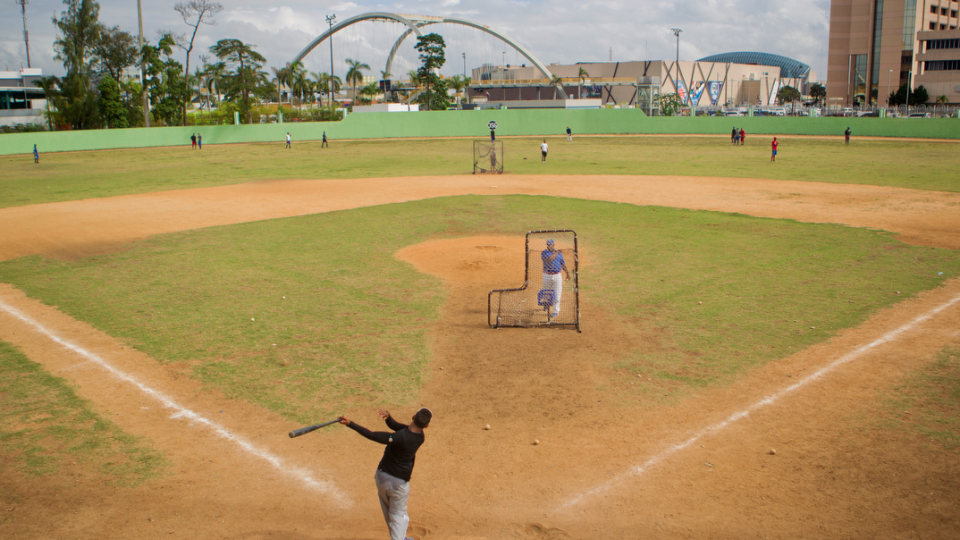 A shortstop takes batting practice at the Centro Olimpico baseball field in Santo Domingo.  “Two Wings to Fly: Stories of fear, hope and economics in the Dominican Republic” tells a variety of stories, from sex workers to teen pregnancy; baseball hopefuls to cockfighting; and many more.