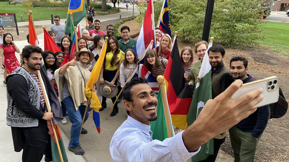 Students gather to take a selfie before marching with their national flags during the 2021 Homecoming Parade. The 2021 Global Nebraska annual report highlights significant advancements in expanding global learning opportunities and supporting international students and scholars.