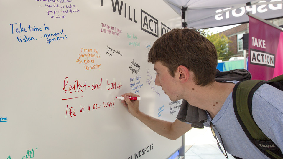 Stephen Cass, a senior history and classics major, makes a pledge after completing the Blind Spots program on the Nebraska Union Plaza.