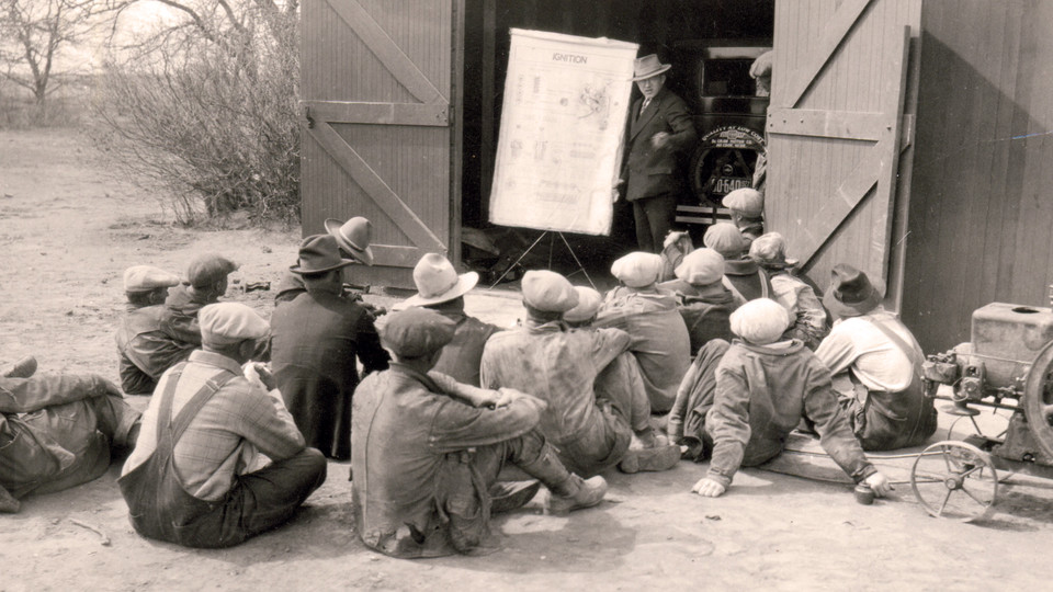 A Nebraska Extension educator discusses how engine ignition systems work to a group of men in this undated photo.