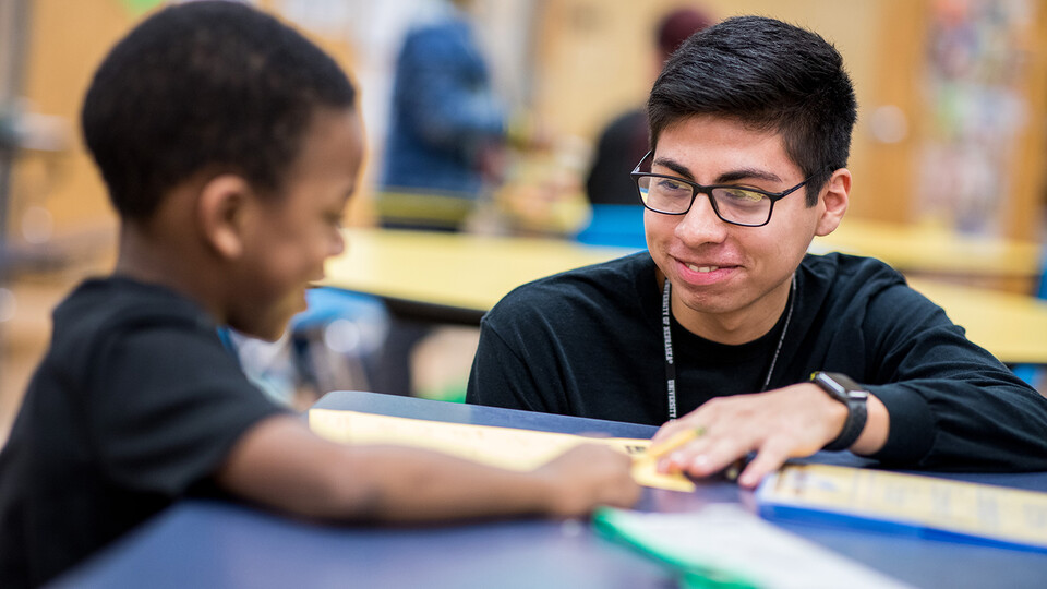 Nebraska's Carlos Ortega works with a student at the Community Learning Center at Lincoln's McPhee Elementary School.