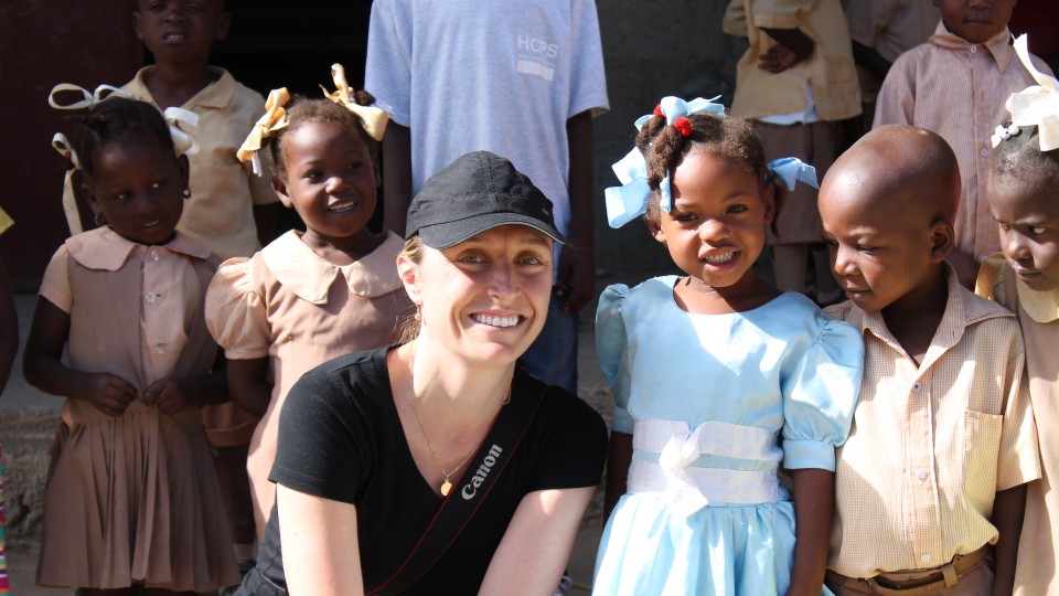 UNL alumna Alaine Knipes poses with schoolchildren during a 2014 trip to Haiti. As part of the Centers for Disease Control and Prevention, Knipes worked to help eliminate a mosquito-borne infection that has afflicted millions throughout the country.