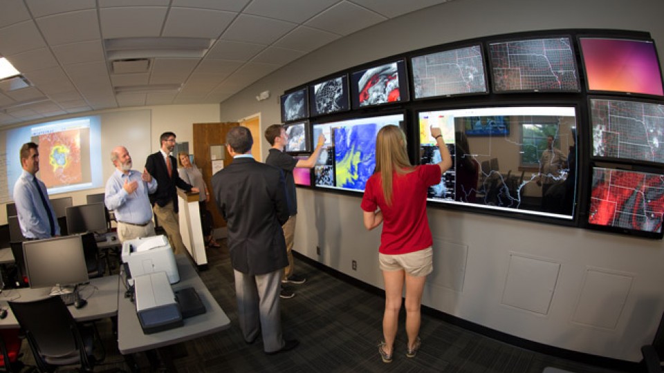 Clint Rowe, left, Professor of Earth & Atmospheric Sciences in the College of Arts and Sciences, describes the touch screen video wall.  Students demonstrated the wall during an open house for the newly remodeled Meteorology-Climatology Computer Lab in Bessey Hall.