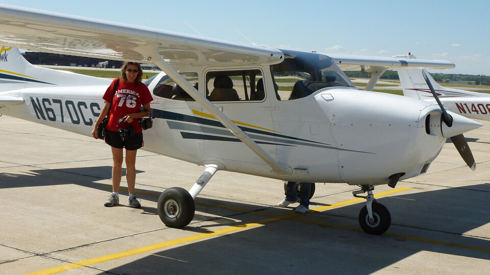 Shawn Hunt standing next to a small airplane on an airport runway.