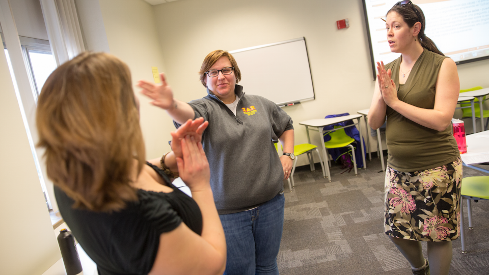 Kelly Kingsbury Brunetto watches as Jocelyn Swanson and Eleanor Dynek practice "stage combat". Spanish class where students do improv and one-act plays to help with their speaking skills.