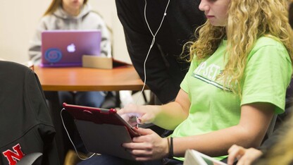 Brian Moore, associate professor of music, listens in on Ashley Dyer's work for an honors seminar. Moore uses iPads extensively in his classes. 