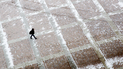 A UNL student walks through a snowy plaza on the east side of Memorial Stadium on Feb. 25. Al Dutcher, the state climatologist, said the winter was the 18th driest since 1896.