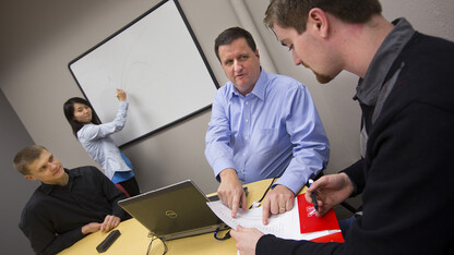 Eric Thompson (second from right), associate professor of economics, works with student research assistants in the College of Business Administration’s Bureau of Business Research. The bureau is designed to assist with Nebraska’s economic development efforts.