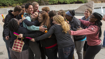 Eddie Welles, (left, in blue) a sophomore marketing major, smiles after accepting a group hug from members of UNL's Thompson Scholars group. The hugs were part of a sociology project designed to break social norms.