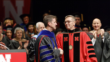 Hank Bounds (left), president of the University of Nebraska system, congratulates Chancellor Ronnie Green after officially installing Green as Nebraska's 20th chancellor. Gov. Pete Ricketts applauds in the background.