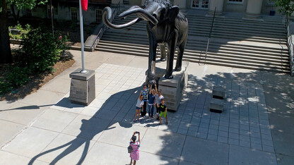 NU State Museum visitors pose for a photo with Archie outside of Morrill Hall.