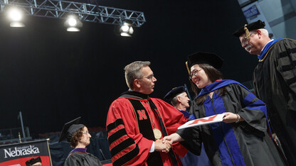 Chancellor Ronnie Green shakes hands with a graduate during summer commencement exercises. Nearly 700 degrees were awarded on Aug. 12.