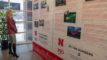 Nebraska's Diane Mendenhall reads about a key historic moment in the university's history as she looks at the N150 traveling exhibition in the Nebraska Union.