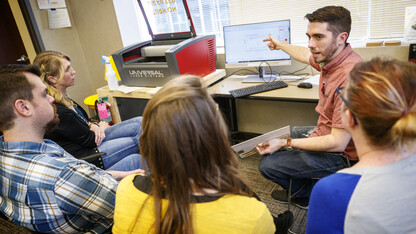 Max Wheeler (pointing to computer screen), NIS instructional designer, leads a training for Library Innovation Studios May 22.