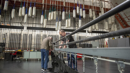 Lied Center for Performing Arts employees remove a stage-spanning curtain prior to the arrival of "The Phantom of the Opera" production. The Lied Center completed nearly $400,000 in upgrades to bring the production to Lincoln.