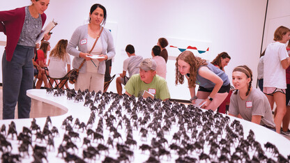 Student and Yazidi participants inspect part of the “Unquiet Harmony: The Subject of Displacement” exhibit at the Sheldon Museum of Art.