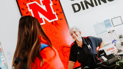 Lory chats with a student at the Cather Dining register