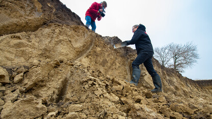 Judy Turk, an assistant professor of natural resources, digs into a profile of soil outside of Lincoln as Curt Bright films the project. Like other campus instructors, Turk is using video as a teaching mechanism to transition a lab course to remote access learning.