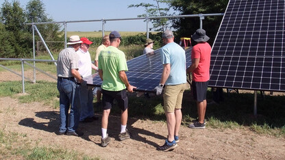 Workshop participants help assemble a solar photovoltaic array at a hands-on workshop during summer 2018.