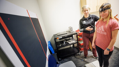 Dr. Kate Higgins, an athletic neuropsychologist with Husker Athletics, performs a concussion balance test on mock patient Makayla Burchett, a freshman from Harlan, Iowa. Burchett wears a laser pointer as she moves her head around a target on the wall while balanced on a force plate. Nebraska Medicine recently moved its concussion clinic to the Nebraska Athletic Performance Lab in Memorial Stadium.