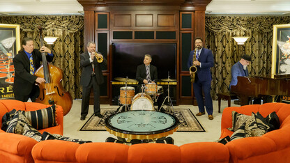 Metro Jazz Quintet performs in an elaborate lounge with an orange sofa.