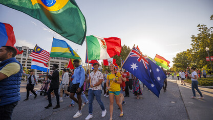 International students carry the flags of their native countries during the 2022 homecoming parade.