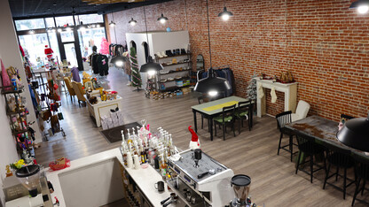 A boutique and coffee shop with tables for customers.