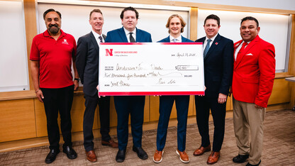 Six men pose with an oversized check for $2,500.