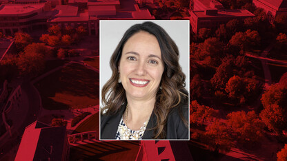 Color portrait of Cheryl Horst on red campus background