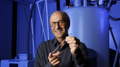 David Berkowitz holds a nuclear magnetic resonance tube in a lab.