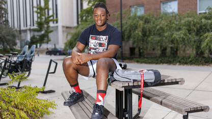 Mi’Khel Thomas, a first-year business and law major at Nebraska, sits atop a picnic table on campus.