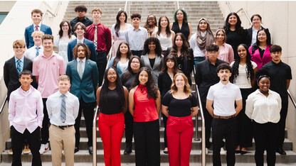 Thirty-four members of the 2024-25 Inclusive Business Leaders cohort pose for a photo on a staircase.