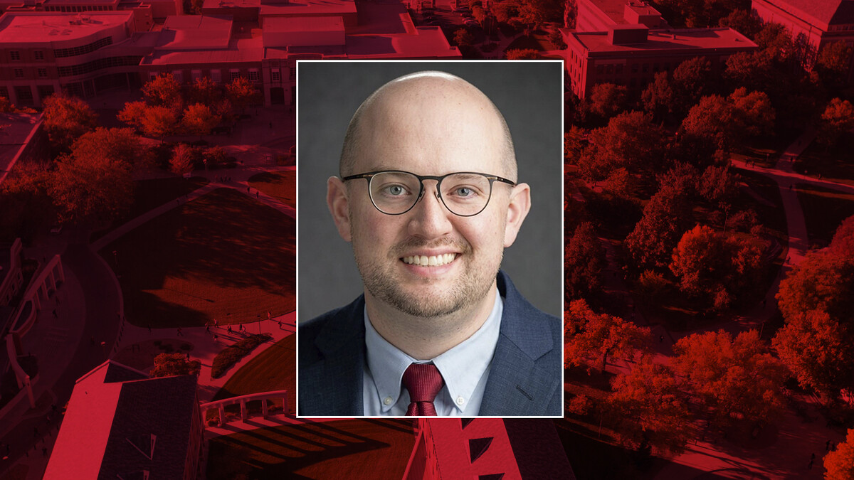 Color portrait of Zane Gernhart on a red campus background.