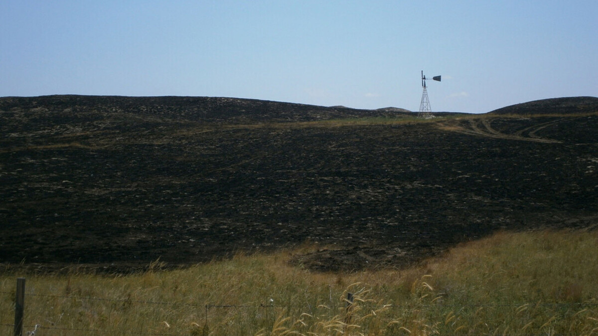 A windmill stands in a charred field in western Nebraska.