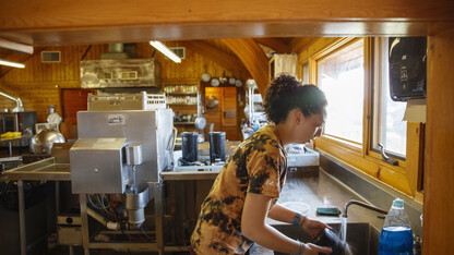 Hailey Showalter rinses dishes after the noon lunch rush.