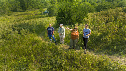 William Belcher, associate professor of anthropology (left); LuAnn Wandsnider, professor of anthropology; Sophia Perdikaris, director of the School of Global Integrative Studies; and  Kat Krutak-Bickert, unit coordinator for SGIS, look over the Reller Prairie Field Station.