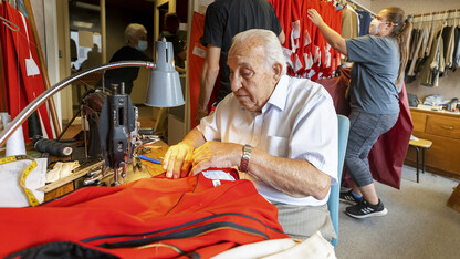 Demetrios Delgiannis alters a pair of band pants as his wife Stamatia helps band members pick up their finished uniforms before the first home game of 2021.