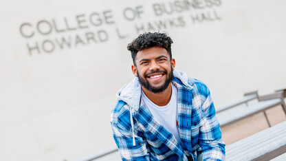 Derek Branch sitting on a bench outside of Howard Hawks Hall.