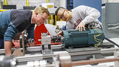 Jun Wang, on right, explains power trains in an electrical engineering lab. 