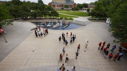 Students walk through campus between the Nebraska Union and the green space, near Broyhill Fountain