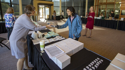 Jing Zhang, assistant professor of biochemistry, picks up her 10-year service award from Karen Bentz in the Lied Commons on Sept. 28. Zhang was among the nearly 1,000 employees honored for their years of service to the university. The service awards ceremony was held prior to the State of Our University address.