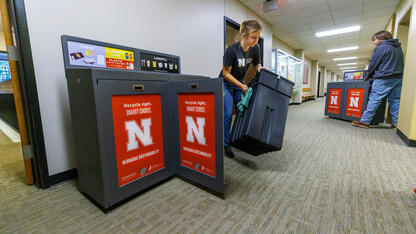 people placing new recycling containers in buildings