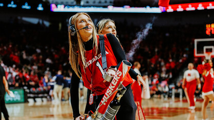 Ashley Beckman works the T-shirt machine on the court during a Husker Basketball game