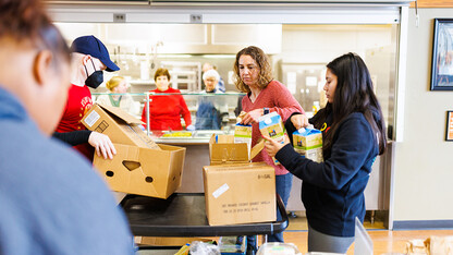 Rev. Zac Wolfe, left, Rebecca Baskerville, Associate Director for Experiential & Global Learning, and Bree Bell, a freshman in marketing from Omaha, unload food for the lunch crowd at Matt Talbot.