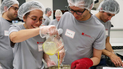 Carmen Perez-Donado pours egg into a mixture as David Fabian Gomez Quintero stirs during the Battle of the Food Scientists Feb. 15 at the Food Innovation Center.